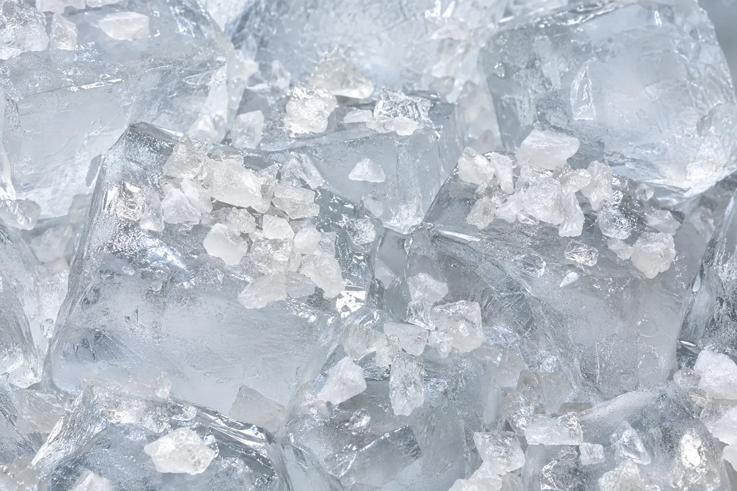 Whitish-clear mineral granules scattered over large clear ice cubes